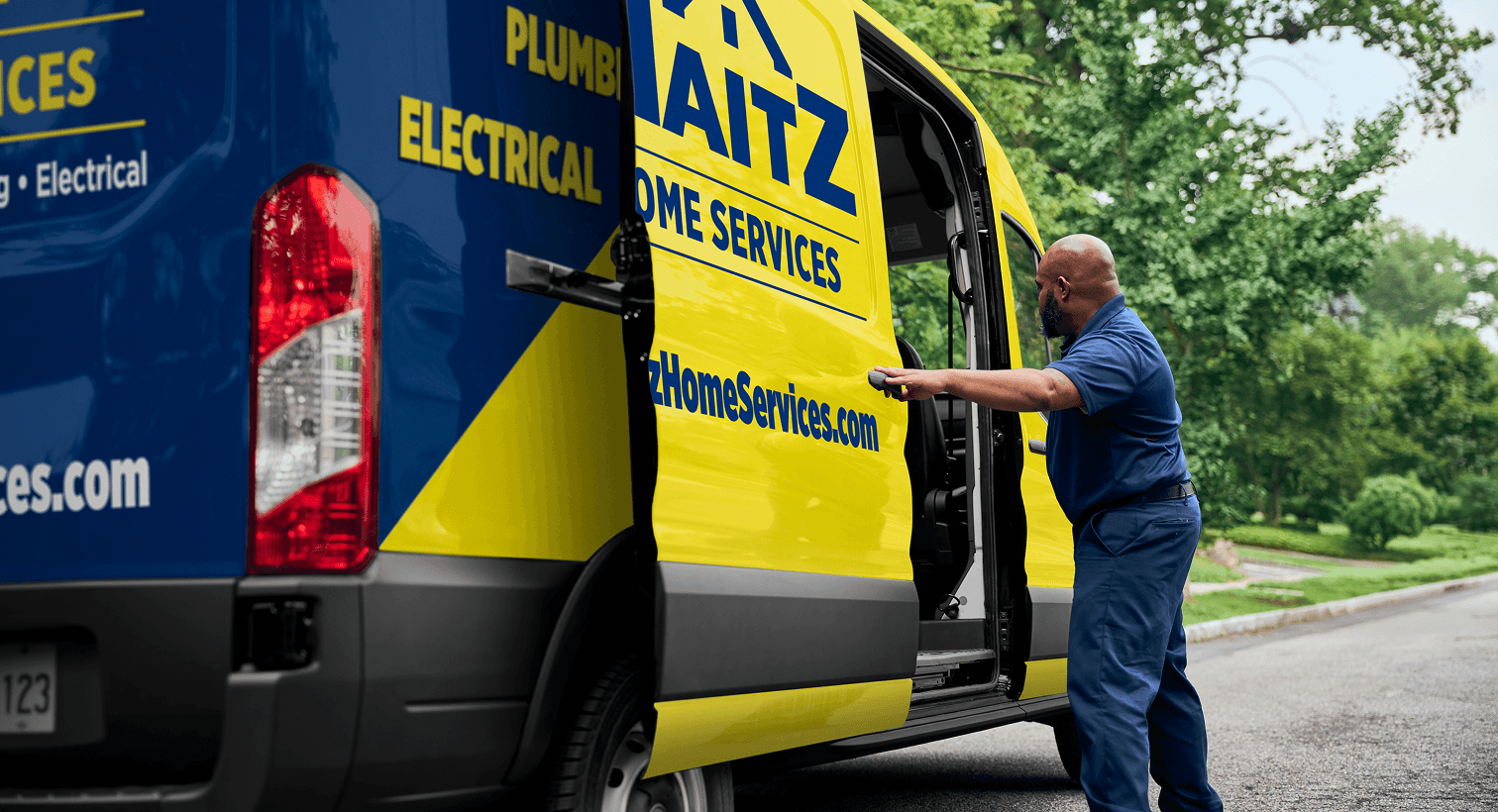 A professional Maitz technician opening a service van on a residential street, ready to provide home HVAC, plumbing, and electrical services.