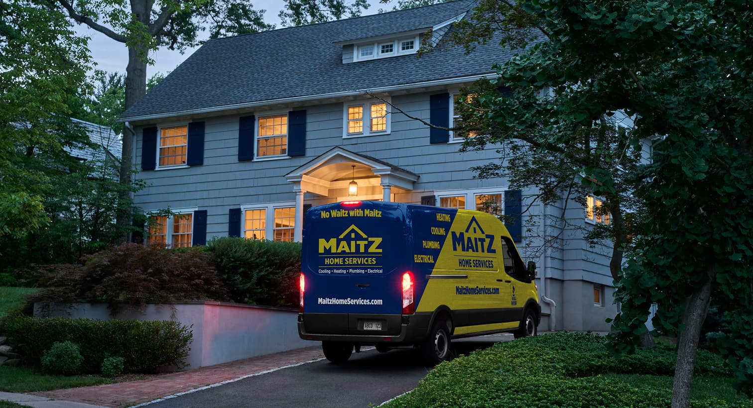 A Maitz service van parked in a residential driveway at night, arriving to provide 24/7 emergency heating repair services.