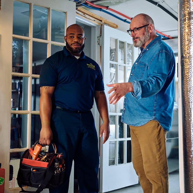 A Maitz technician discusses the repair and installation services with a homeowner.